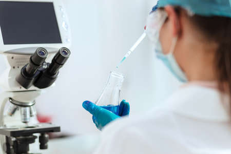 close up. female laboratory assistant testing liquid in a laboratory bottle.