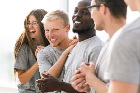 group of happy young people standing in a bright room