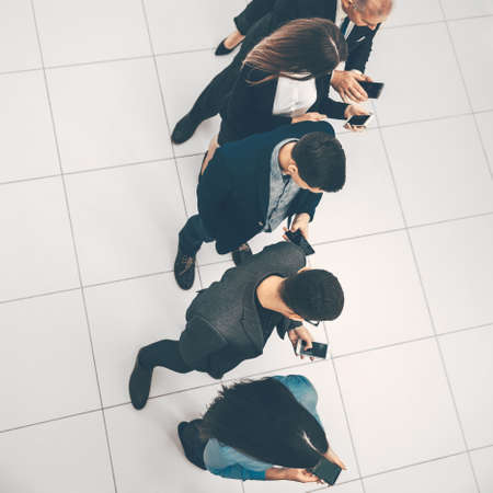 top view. a group of business people looking at their smartphon screens.の写真素材