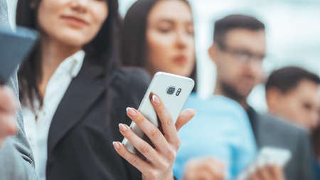 group of young business people reading messages on their smartphones