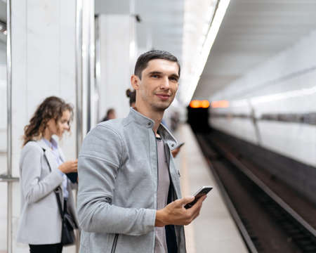 young man waiting for a train on the subway platform.の写真素材