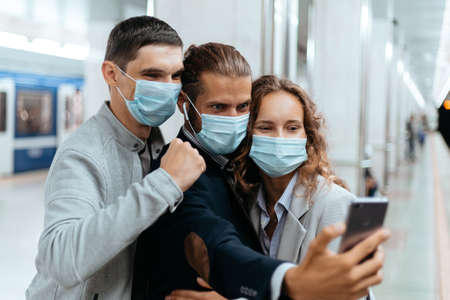group of passengers in protective masks taking selfies in the subway.の写真素材