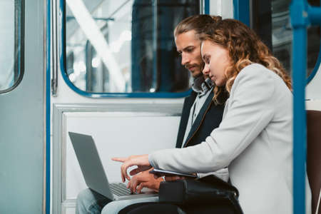 beautiful young couple sitting in a subway car.の写真素材