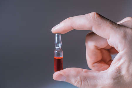 close up. ampoule with the vaccine in hand .