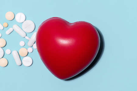 red heart and pills on a blue background .
