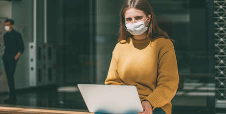 young woman works on a laptop during a pandemicの写真素材