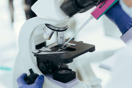 close up. scientist using an automatic dispenser during his research