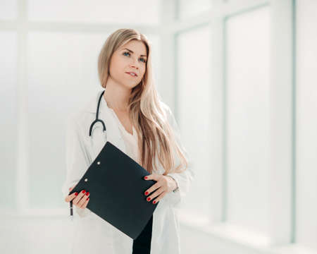 female therapist with a clipboard, standing near the hospital wの写真素材