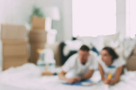 background image of a young couple lying on the floor in an empty new apartment.の写真素材