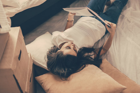 young woman with a project of her apartment lying on the floor.の写真素材