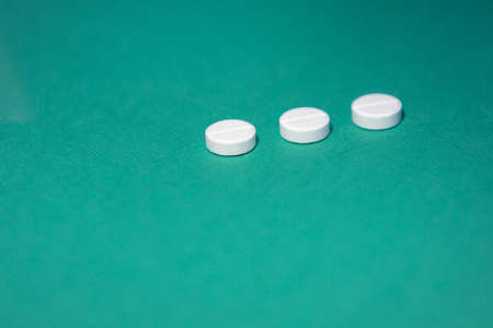 close up. three tablets on a green background.