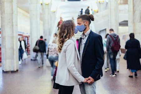 couple in love standing at a subway station .