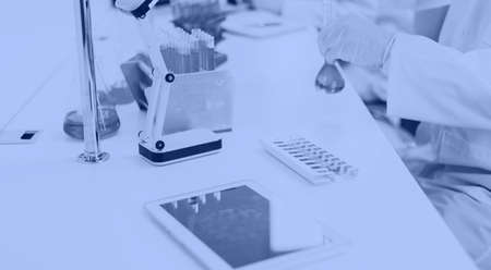 digital tablet and ampoules with the vaccine on the table in the laboratory.