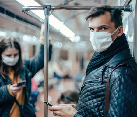 passengers in protective masks standing in the subway car.の写真素材