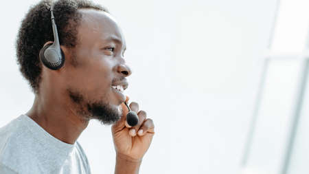 side view. young man with headset talking into microphone