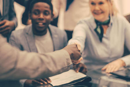 close up. smiling international business partners shaking handsの写真素材