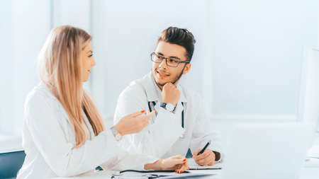 doctors colleagues talking sitting at a table in the officeの写真素材