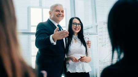 boss introducing a young speaker during a business presentation