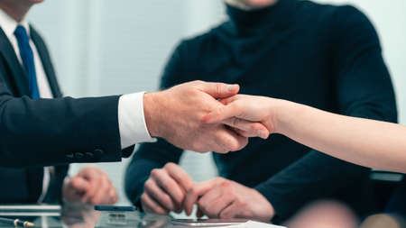 serious businessman shaking hands with a young business manの写真素材