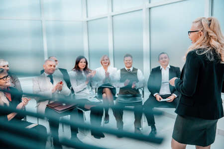 through the blinds. working group sitting in the conference room.の写真素材