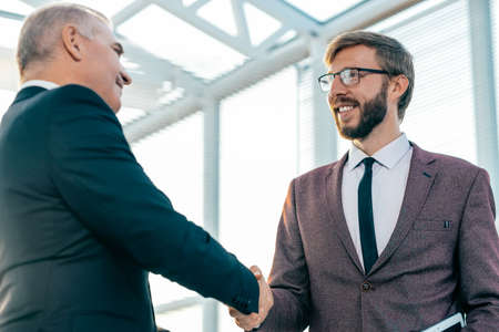 close up. confident business people firmly shaking handsの写真素材