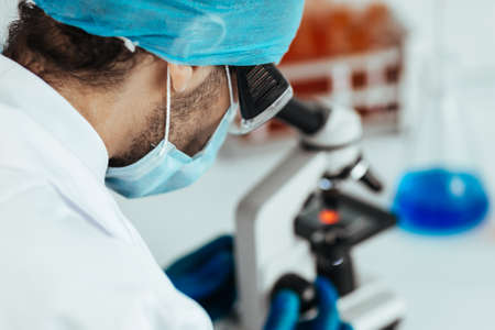 scientist looking at a drop of blood through a microscope.の写真素材
