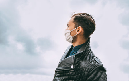 man in a protective mask against the background of a modern cityの写真素材