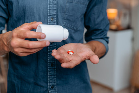 young man holds pills in the palm of his hand.の写真素材