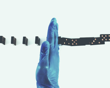 close up. epidemiologist in protective gloves, placing dominoes.の写真素材