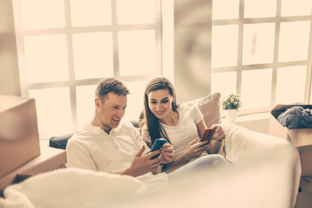 happy young couple looking at their smartphone screen .の写真素材