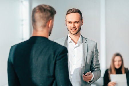 business colleagues discuss something standing in the officeの写真素材