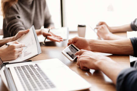 employee is using his smartphone to check the financial data.