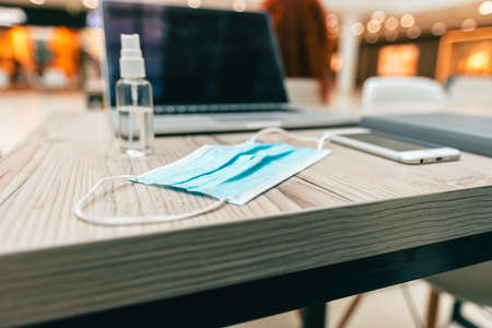 laptop and personal protective equipment on the tableの写真素材