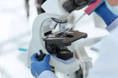 close up. scientist using an automatic dispenser during his research
