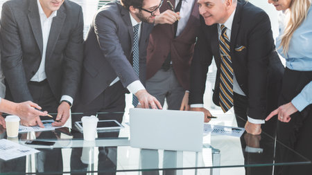 group of employees enthusiastically looking at the laptop screenの写真素材