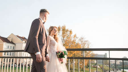 happy couple newlyweds standing on the bridge.の写真素材