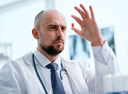scientist with an ampoule of vaccine sitting at a laboratory table .の写真素材