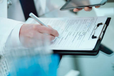 laboratory assistant with a digital tablet filling out a medical form.