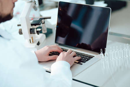 science lab technician using a laptop in the lab.の写真素材