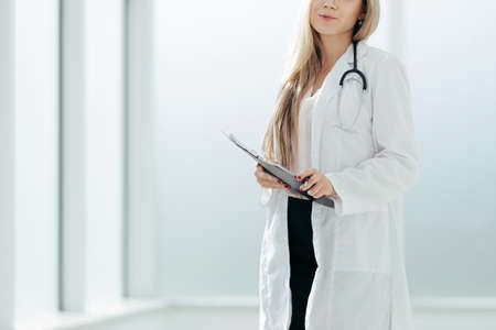 female therapist with a clipboard, standing near the hospital wの写真素材