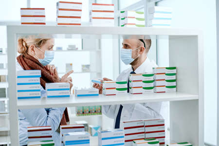 image of a pharmacist explaining something to a mature woman.