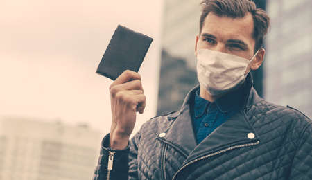 young man in a protective mask showing his passportの写真素材
