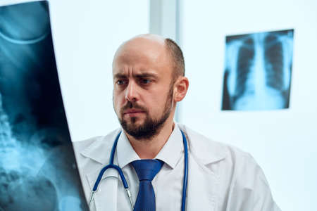 serious doctor studying an X-ray of a patient.の写真素材