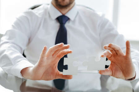 image of a happy businessman putting together the puzzle pieces.の写真素材