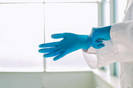 doctor putting blue protective gloves. concept of security.