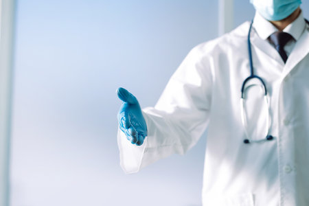 doctor with a stethoscope holding out his hand for a handshake .の写真素材