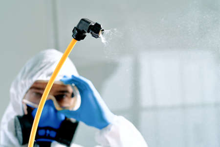 professional disinfector in a biohazard suit adjusting safety glasses.の写真素材