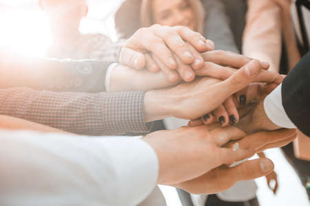 close up. a group of young business people forming a tower out of their handsの写真素材