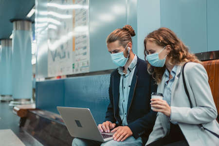 young couple with a laptop on the subway platform .の写真素材