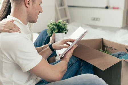 young couple sitting on the floor in a new apartment.の写真素材